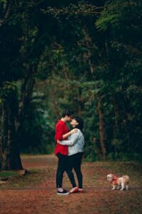 Man And Woman Kissing Holding Dog With Leash