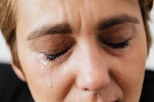 Tears on face of crop anonymous woman