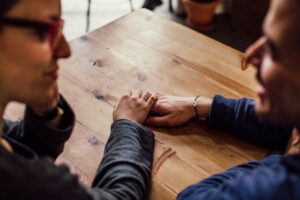 Man and Woman Sitting Together in Front of Table